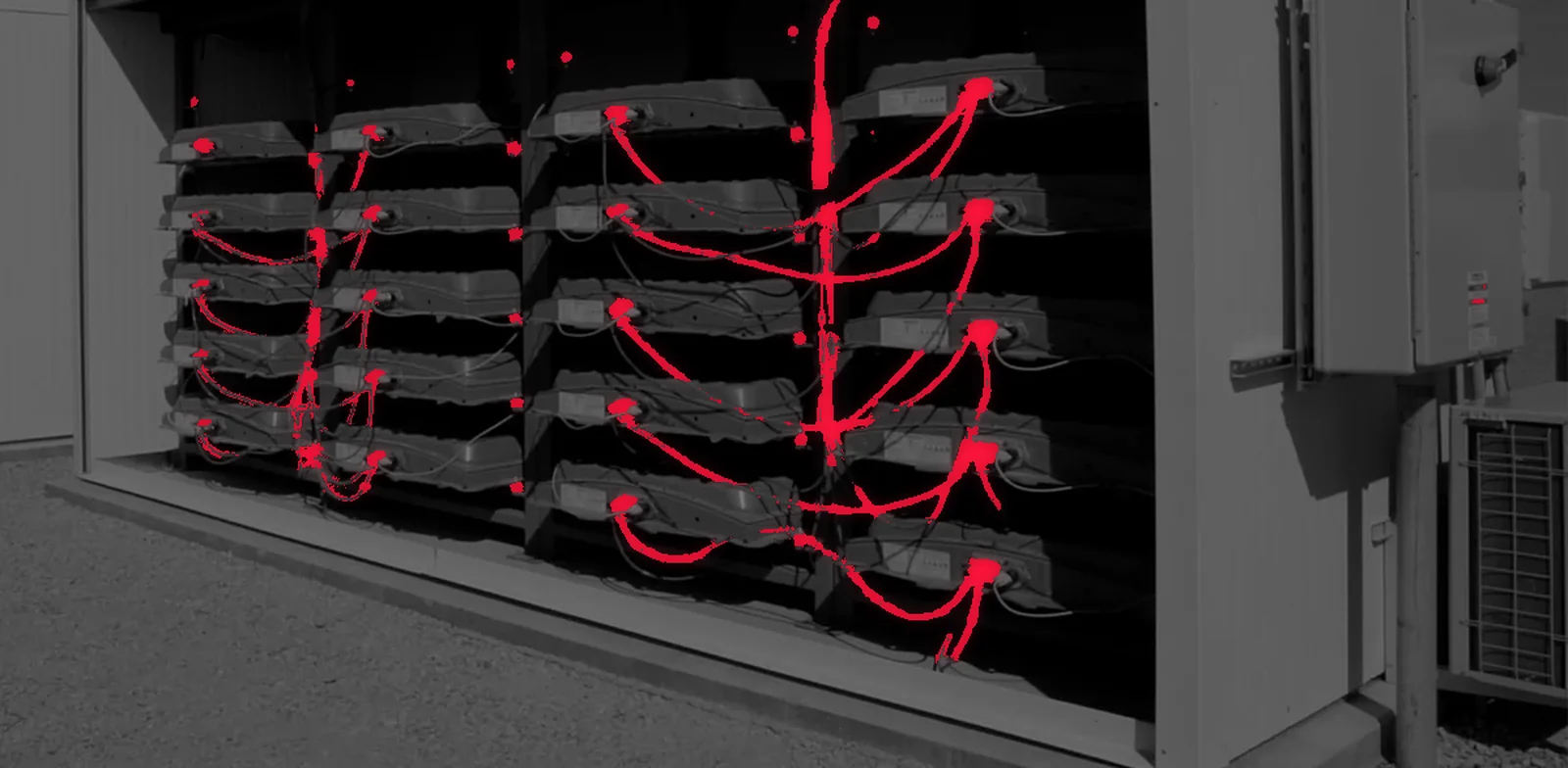 B2U Distributed Power System: open battery storage container, repurposed EV battery modules wired together with red high-voltage cables; greyscale with the red cabling preserved and bloom around the cables.